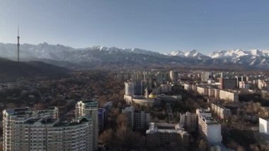 Güneşli bir ilkbahar gününde, Kazak şehri Almaty 'nin güneydoğusundaki bir dörtlüden bir dağ sırasının arka planına bakan görüntüler.