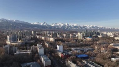 Güneşli bir ilkbahar gününde, Kazak şehri Almaty 'nin güneydoğusundaki bir dörtlüden bir dağ sırasının arka planına bakan görüntüler.