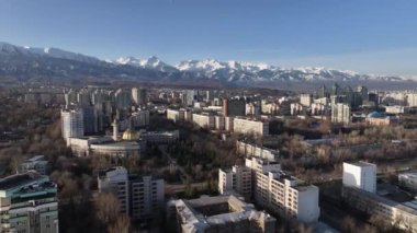 Güneşli bir ilkbahar gününde, Kazak şehri Almaty 'nin güneydoğusundaki bir dörtlüden bir dağ sırasının arka planına bakan görüntüler.