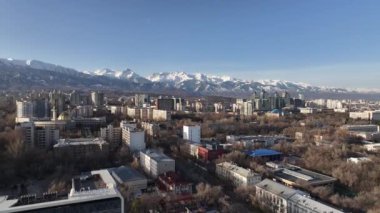 Almaty, Kazakistan. 04.02.2024. Güneşli bir ilkbahar gününde, Kazak şehri Almaty 'nin güneydoğusundaki bir dörtlüden bir dağ sırasının arka planına bakan görüntüler.