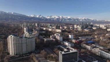 Almaty, Kazakistan. 04.02.2024. Güneşli bir ilkbahar gününde, Kazak şehri Almaty 'nin güneydoğusundaki bir dörtlüden bir dağ sırasının arka planına bakan görüntüler.