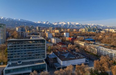 Almaty, Kazakistan. 02.04.2024. Güneşli bir ilkbahar gününde, Kazak şehri Almaty 'nin güneydoğusundaki bir dörtlüden bir dağ sırasının arka planına bakan görüntüler.