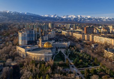 Güneşli bir ilkbahar gününde, Kazak şehri Almaty 'nin güneydoğusundaki bir dörtlüden bir dağ sırasının arka planına bakan görüntüler.