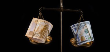 Altın pulunun bir tarafında 100 ruble banknot ve terazinin diğer tarafında 100 dolar.