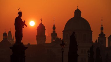 Çek Cumhuriyeti 'nin başkenti üzerinde gün doğumu - Prag şehri binaların ve heykellerin siluetleriyle