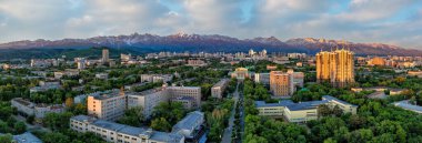 Bir bahar sabahı, Kazak şehri Almaty 'nin merkez kısmının bir kuadkopter görüntüsü bir dağ sırasının arka planına karşı.