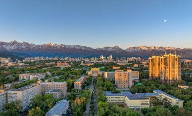 Bir bahar sabahı, Kazak şehri Almaty 'nin merkez kısmının bir kuadkopter görüntüsü bir dağ sırasının arka planına karşı.