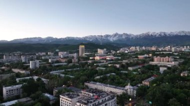 Bir bahar sabahı, Kazak şehri Almaty 'nin merkez kısmının bir kuadkopter görüntüsü bir dağ sırasının arka planına karşı.