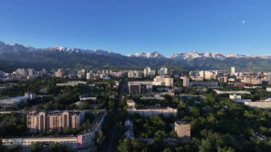 Bir bahar sabahı, Kazak şehri Almaty 'nin merkez kısmının bir kuadkopter görüntüsü bir dağ sırasının arka planına karşı.