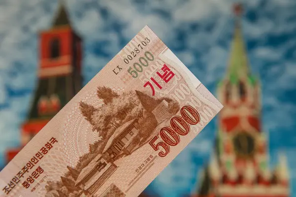 stock image 5000 won banknote of the Korean People's Democratic Republic against the backdrop of the Moscow Kremlin buildings