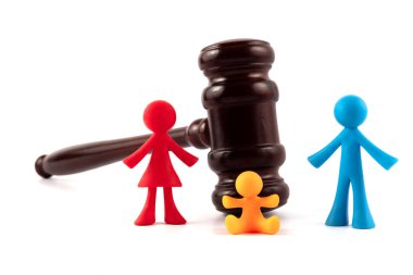 Bir çocuklu senfonik bir ailenin figürleri ve beyaz bir arkaplanda yargıç tokmağı.