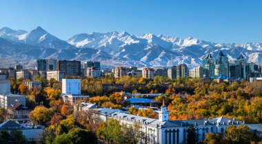 Bir sonbahar sabahı arka planda karla kaplı dağlarla birlikte Kazak şehri Almaty 'nin orta kısmının havadan görünüşü
