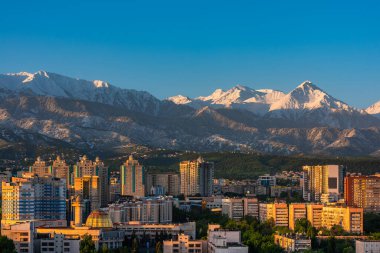 Bir bahar sabahı arka planında karla kaplı dağlarla Kazak şehri Almaty 'nin merkez kısmının havadan görüntüsü.