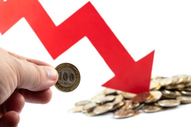 Kazak para biriminin döviz kuru hakkında kavramsal bir hikaye. Bir adamın elinde 100 onluk bir para ve düşen bir grafiğin kırmızı oku var.