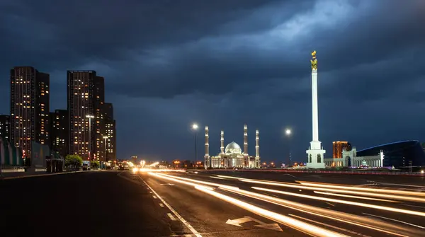 stock image  Kazakhstan Independence Monument with the magical bird Samruk on top and the Khazret-Sultan Mosque in Astana on a summer evening