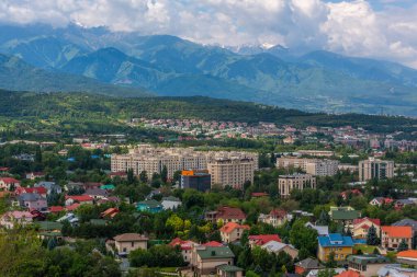 Bulutlu bir yaz gününde Kazak şehri Almaty 'nin yükselen eteklerinin manzarası.