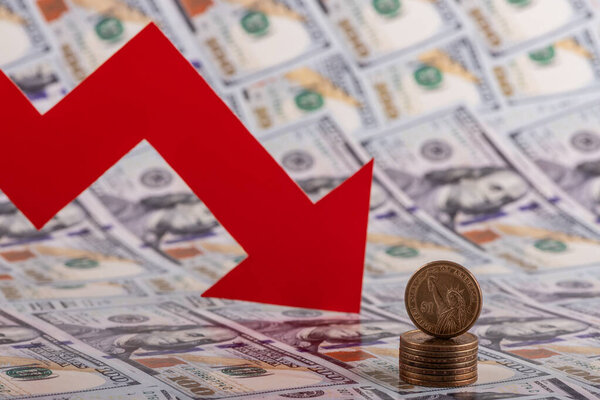 1 Доллар США монета и красный падающий финансовый график стрелка на фоне 100 долларов США купюры