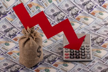 100 dolarlık banknotların arka planında Amerikan doları sembolü olan kırmızı finansal grafik oku, hesap makinesi ve para çantası