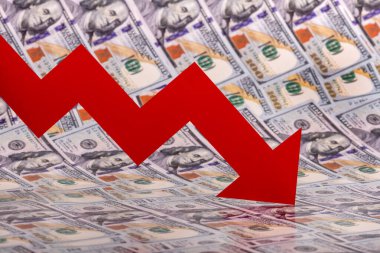 100 dolarlık banknotların arka planında kırmızı düşen finansal grafik oku