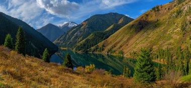 Kazakistan 'ın Almaty bölgesindeki Kolsai Gölü' nün resimli sonbahar manzarası