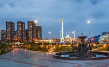  Astana, Kazakistan, 06.20.2017. Başkent Kazakistan 'ın merkez kısmının akşam manzarası - Çeşmelerden Astana şehri Saka savaşçıları ve Independence Meydanı şeklinde