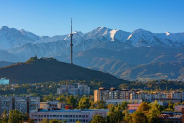 Kazak şehri Almaty 'nin merkez kısmının bir sonbahar sabahı bir dağ sırasının arka planına karşı görüntüsü