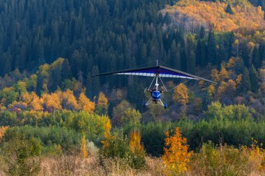 Almaty, Kazakistan, 10.05.2024. Bir sonbahar günü, bir trike dağların arka planında uçar.