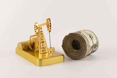 Minyatür altın yağ pompası ve 1 dolarlık banknotlar.