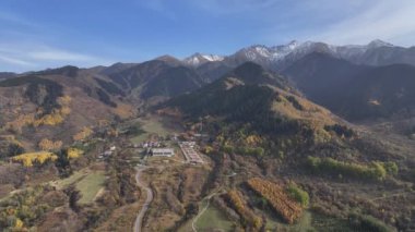 Almaty bölgesi, Kazakistan, 10.05.2024. Trans-Ili Alatau dağlarının resimli yamaçlarında bir sonbahar akşamı Kazakistan 'ın güneydoğusunda sarı ağaçlar ve köknar ağaçları vardı.