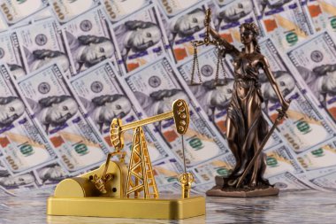 Bu rakam ve minyatür bir yağ pompası 100 dolarlık banknotların arka planına karşı.