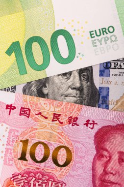 Banknotes in denominations of 100 dollars, 100 euros and 100 Chinese yuan clipart