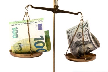 Terazinin bir tarafındaki 100 dolarlık banknot, terazinin diğer tarafındaki 100 avroluk banknottan ağır basıyor..