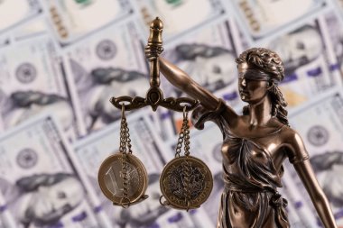 1 avro ve 1 İngiliz poundu Themis terazisinde 100 Amerikan dolarının arka planına karşı.