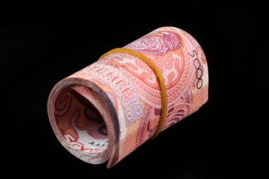 Yuvarlanmış 5000 Kazakistan banknotu siyah arka planda.