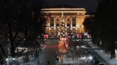 Almaty, Kazakistan, 01.09.2025. Almaty 'nin merkezinde yer alan Opera ve Bale Tiyatrosu' nun bir kuadkopterinden bir kış akşamında Noel ağacı ile görüntülenir.