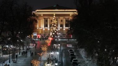 Almaty, Kazakistan, 01.09.2025. Almaty 'nin merkezinde yer alan Opera ve Bale Tiyatrosu' nun bir kuadkopterinden bir kış akşamında Noel ağacı ile görüntülenir.