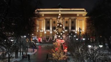 Almaty, Kazakistan, 01.09.2025. Almaty 'nin merkezinde yer alan Opera ve Bale Tiyatrosu' nun bir kuadkopterinden bir kış akşamında Noel ağacı ile görüntülenir.