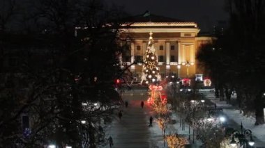 Almaty, Kazakistan, 01.09.2025. Almaty 'nin merkezinde yer alan Opera ve Bale Tiyatrosu' nun bir kuadkopterinden bir kış akşamında Noel ağacı ile görüntülenir.