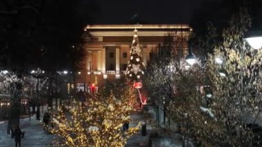 Almaty, Kazakistan, 01.09.2025. Almaty 'nin merkezinde yer alan Opera ve Bale Tiyatrosu' nun bir kuadkopterinden bir kış akşamında Noel ağacı ile görüntülenir.