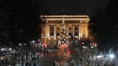 Almaty, Kazakistan, 01.09.2025. Almaty 'nin merkezinde yer alan Opera ve Bale Tiyatrosu' nun bir kuadkopterinden bir kış akşamında Noel ağacı ile görüntülenir.