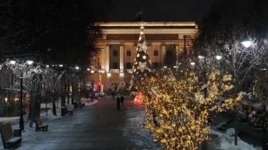 Almaty, Kazakistan, 01.09.2025. Almaty 'nin merkezinde yer alan Opera ve Bale Tiyatrosu' nun bir kuadkopterinden bir kış akşamında Noel ağacı ile görüntülenir.