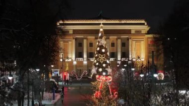 Almaty, Kazakistan, 01.09.2025. Almaty 'nin merkezinde yer alan Opera ve Bale Tiyatrosu' nun bir kuadkopterinden bir kış akşamında Noel ağacı ile görüntülenir.