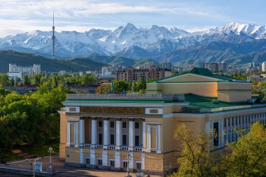 1941 'de inşa edilen opera ve bale tiyatrosu ile Kazak şehrinin merkez kısmının havadan görünüşü bir bahar sabahı bir dağ sırasının arka planına karşıdır.