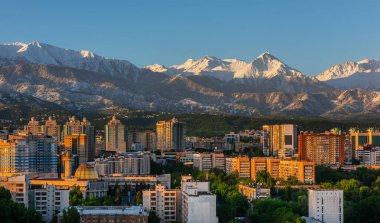 Kazak şehri Almaty 'nin merkez kısmının havadan görünüşü bir bahar sabahı bir dağ sırasının arka planına karşı.