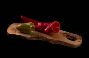 Kesme tahtasında kırmızı ve yeşil dolma biber