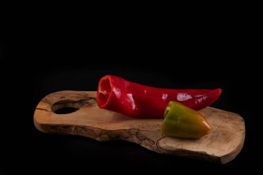 Kesme tahtasında kırmızı ve yeşil dolma biber