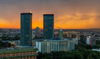 Almaty, Kazakistan, 07.22.2020. Gün batımında bir yağmur bulutunun arkaplanına karşı Kazak şehri manzarası