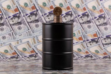 Arka planda 100 dolarlık banknotlar olan metal yağ fıçısı.