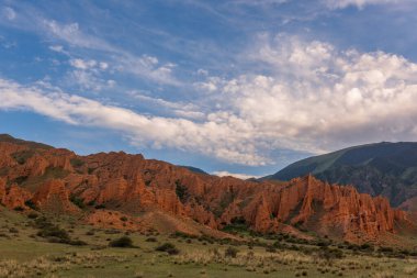 Güneydoğu Kazakistan 'da bulutlu bir yaz gününde resimli kırmızı kayalar.