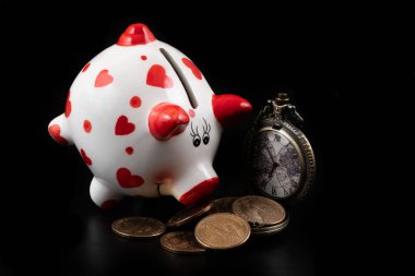 Domuz kumbarası, antika cep saati ve siyah arka planda 1 Amerikan doları.